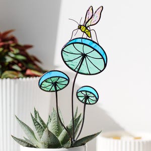 Gebrandschilderd glasmug op blauwe paddestoelplant. Grappig handgemaakt cadeau voor tuinders en natuurliefhebbers