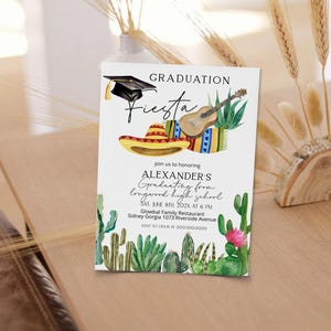 Puede incluir: Una invitaci&oacute;n a una fiesta de graduaci&oacute;n con una ilustraci&oacute;n de acuarela de un sombrero, una guitarra y cactus. El texto dice "Graduation Fiesta" e incluye el nombre del graduado, la fecha, la hora y el lugar.