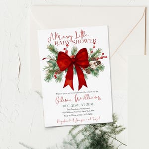 Peut inclure: Une carte d'invitation pour baby shower blanche avec un grand n&oelig;ud rouge, des branches de pin vertes, des baies rouges et des pommes de pin. Le texte indique A Merry Little BABY SHOWER, Olivia Williams, Dec. 21st, at 5pm, The Grandview Restaurant.