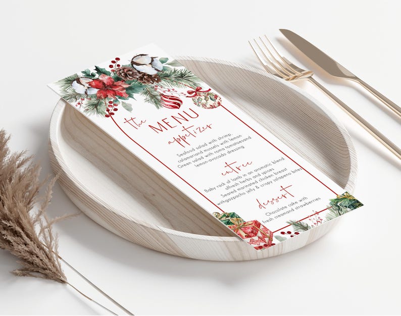May include: A rectangular menu card featuring a watercolor illustration of poinsettias, pine cones, and ornaments. The text reads THE MENU, appetizer, entree, and dessert, with listed food items. The card is placed on a round plate with cutlery.