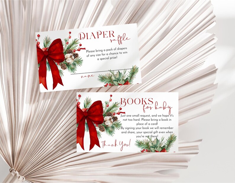 Peut inclure: Deux cartes rectangulaires blanches avec une illustration &agrave; l'aquarelle d'un grand n&oelig;ud rouge, de branches de pin, de pommes de pin et de baies rouges. La carte du haut indique DIAPER raffle avec des instructions. Celle du bas indique BOOKS for baby.