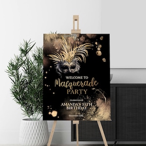 Könnte beinhalten: Ein schwarzes und goldenes Willkommenszeichen für eine Maskenballparty. Das Schild zeigt eine goldene Maske mit Federn und goldenen Farbspritzern. Der Text lautet "Willkommen zur Maskenballparty, Feier des 35. Geburtstages von Amanda, 29. Dezember".