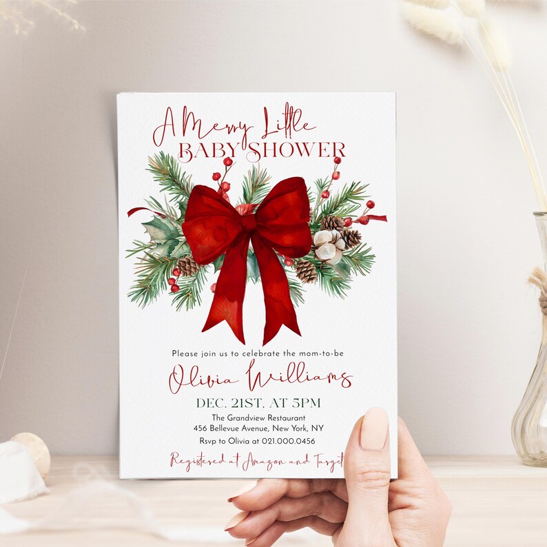 Peut inclure: Une carte d'invitation rectangulaire pour une f&ecirc;te pr&eacute;natale avec le texte A Merry Little BABY SHOWER en rouge. Un grand n&oelig;ud rouge est plac&eacute; sur des branches de pin vertes, des baies rouges et des pommes de pin. D&eacute;tails pour Olivia Williams.