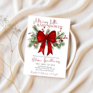 Peut inclure: Une carte d'invitation rectangulaire blanche pour une f&ecirc;te pr&eacute;natale avec un grand n&oelig;ud rouge, des branches de pin vertes, des pommes de pin et des baies rouges. Le texte indique A Merry Little BABY SHOWER, Olivia Williams, Dec. 21st, at 5pm.