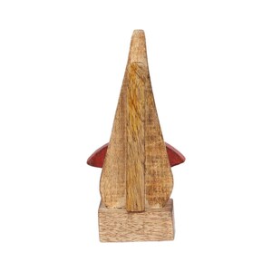 May include: Wooden figurine of a stylized bird with a red beak and wings. The bird is standing on a wooden base.
