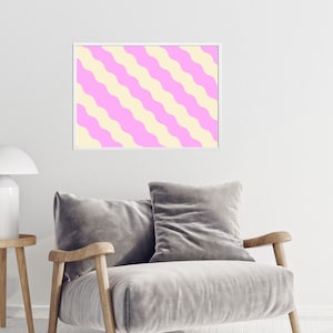 May include: A framed print with a pink and yellow wavy striped pattern. The print is in a white frame and is hanging on a white wall.