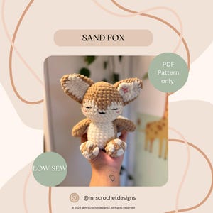 May include: A crocheted sand fox plushie with a tan and white color scheme. The fox has large ears, closed eyes, and small paws. The text "SAND FOX" and "PDF Pattern only" are visible. The text "LOW SEW" is also visible.
