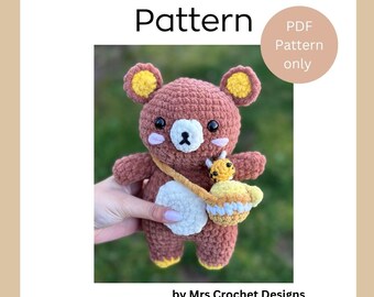 Op de afbeelding: Haakpatroon voor een bruine KUMMA-beer met gele oren en een gele en witte gehaakte tas. Het patroon is beschikbaar als PDF-download. Het patroon is van Mrs. Crochet Designs. De Instagram-handle is @mrscrochetdesigns.