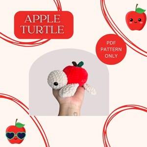 Può includere: Uno schema all'uncinetto per una tartaruga di mela. Lo schema è disponibile per il download in PDF. L'immagine mostra una tartaruga di mela all'uncinetto con un guscio di mela rosso e gambe e testa bianche all'uncinetto.