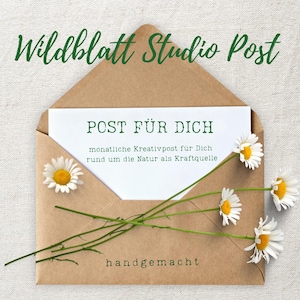 Könnte beinhalten: Ein brauner Kraftpapierumschlag mit einer weißen Karte, bedruckt mit dem grünen Text Wildblatt Studio Post, POST FÜR DICH, monatliche Kreativpost für Dich rund um die Natur als Kraftquelle und handgemacht, verziert mit vier weißen Gänseblümchen.