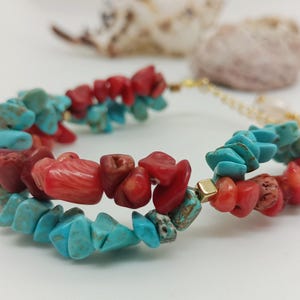May include: A double-strand bracelet made with turquoise and coral beads. The bracelet has a gold clasp.