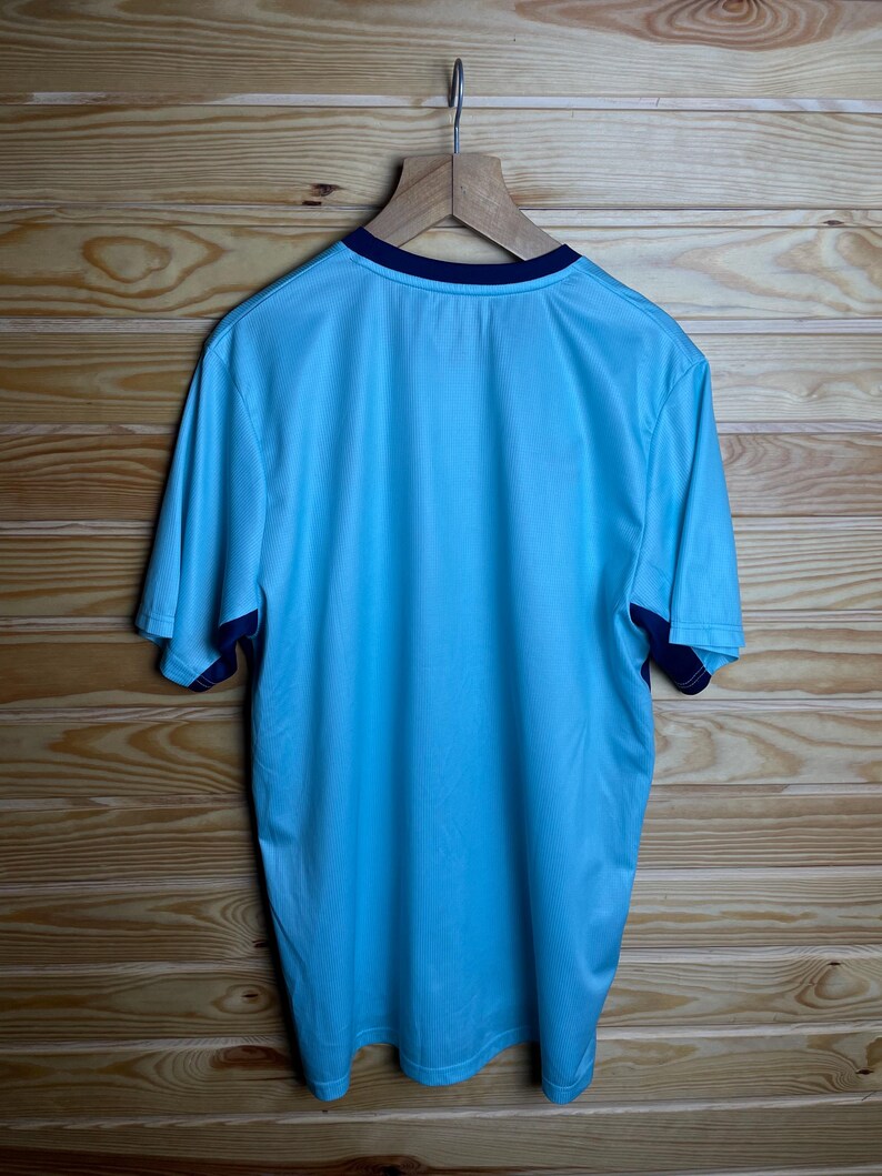 K&ouml;nnte beinhalten: Ein hellblaues T-Shirt mit kurzen &Auml;rmeln und dunkelblauem Besatz an Kragen und &Auml;rmeln.