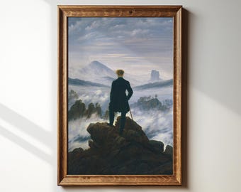 May include: A framed painting depicting a man standing on a rocky outcrop overlooking a sea of clouds. The man is wearing a dark coat and has his back to the viewer. The sky is a pale blue with wispy clouds.