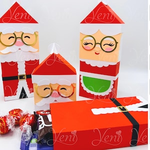 Puede incluir: Cajas de regalo rojas y blancas con temática de Papá Noel y Mamá Noel, y una caja para dinero. Las cajas presentan gafas con montura dorada, barbas blancas y sombreros rojos. La caja para dinero tiene un diseño de cinturón negro. Se ven caramelos.