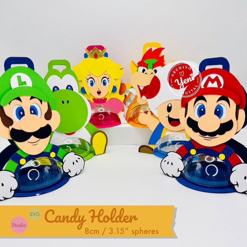Puede incluir: Soportes de caramelos coloridos con personajes de una popular serie de videojuegos. Los soportes tienen forma de Mario, Luigi, Yoshi, Princesa Peach y Toad. Cada soporte tiene un recipiente redondo y transparente. El texto "Candy Holder" y "8cm / 3.15" spheres" es visible.