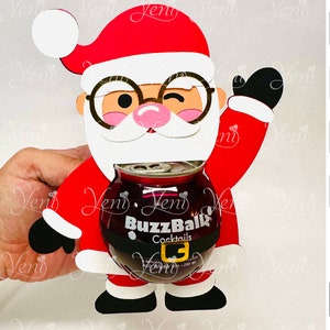 Puede incluir: Un recorte de Papá Noel rojo y blanco con un cinturón negro y una lata de cócteles BuzzBallz en su interior. Papá Noel levanta su mano derecha en señal de saludo. Papá Noel lleva barba blanca y gafas.