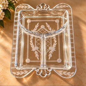May include: A clear glass rectangular serving tray featuring a three-section divided interior. The tray is decorated with etched leaf patterns, a central diamond grid design, and a grid-patterned border with scalloped edges.