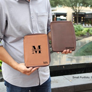 May include: Two brown leather zippered portfolios. One portfolio has the name "Matthew" embossed on the front. The other portfolio has the name "Morganne" and the initial "M" embossed on the front. The portfolios are 9.5 inches by 6 inches by 1 inch.