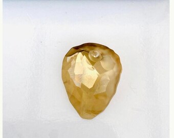 May include: A gold-colored crystal pendant in the shape of a heart. The pendant is faceted and has a hole at the top for stringing.