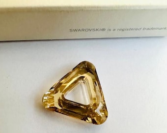 May include: A clear, amber-colored crystal triangle pendant with a hole in the center. The pendant is made by Swarovski.