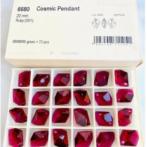 May include: A box of 72 ruby red crystal pendants, each measuring 20 mm. The box is labeled "6680 Cosmic Pendant" and "Ruby (501)".