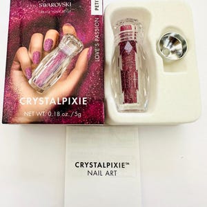 May include: A box of Swarovski Crystalpixie nail art in a petite size, with a clear bottle filled with sparkling red crystals. The box features the text "Love's Passion" and "Create Your Style". The net weight is 5g.
