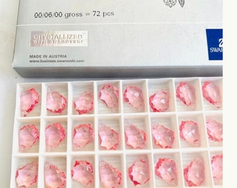 Puede incluir: Una caja de 72 colgantes barrocos de cristal rosa claro, cada uno mide 16,0 mm por 11,0 mm. La caja está etiquetada con "6090 Baroque Pendant MM 16.0X 11.0 Light Rose (223)" y "00/06/00 gross = 72 pcs".