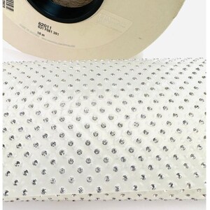 May include: A roll of white, clear, adhesive-backed rhinestones. The roll is 10 metres long and has a label that reads "62011 031 F081 391".