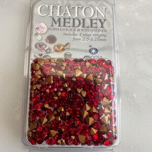 Puede incluir: Un paquete de piedras redondas con dorso puntiagudo rojas y doradas, etiquetado como "CHATON MEDLEY". El paquete incluye cuatro tamaños que van de 2,5 a 4,75 mm. Las piedras están en un recipiente de plástico transparente.