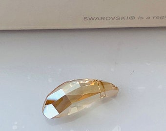 May include: A clear, faceted, teardrop-shaped crystal pendant in a light amber color.
