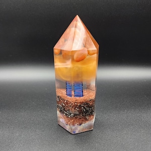 May include: A clear crystal point with layers of orange, brown, blue, and copper wire inside. The crystal point is a hexagonal shape.