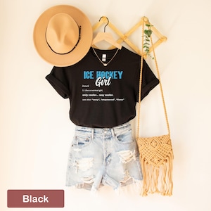 Op de afbeelding: Zwart T-shirt met de tekst "ICE HOCKEY Girl" en een definitie van het woord "Girl" als "Net als een normaal meisje, alleen cooler... veel cooler."