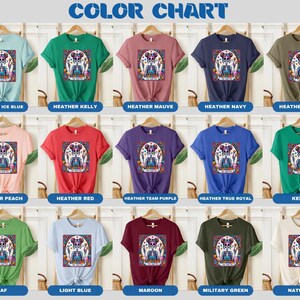 May include: Colour chart displaying 15 different t-shirt colours with a graphic of a sugar skull on each. The colours include Heather Ice Blue, Heather Kelly, Heather Mauve, Heather Navy, Heather Olive, Heather Peach, Heather Red, Heather Team Purple, Heather True Royal, Kelly, Leaf, Light Blue, Maroon, Military Green, and Natural.