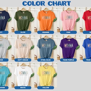 May include: Color chart showing 15 different t-shirt colors. The t-shirts all have the same design, which says "Momma" in a rainbow gradient with the words "Pretty much runs this place" underneath.