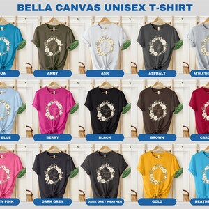 May include: A Bella Canvas unisex t-shirt featuring a floral wreath design and the text "Forever Yours" in gold lettering. The shirt is available in 15 different colours, including aqua, army, ash, asphalt, athletic heather, baby blue, berry, black, brown, cardinal, charity pink, dark grey, dark grey heather, gold, and heather aqua.