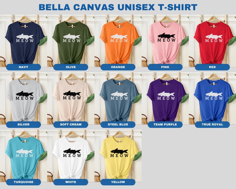 May include: A Bella Canvas unisex t-shirt with a graphic of a fish and the word "MEOW" printed on it. The shirt is available in 12 colors: navy, olive, orange, pink, red, silver, soft cream, steel blue, team purple, true royal, turquoise, white, and yellow.