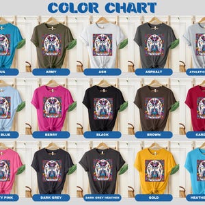 May include: Colour chart displaying 15 different t-shirt colours with a graphic of a sugar skull with flowers on each shirt. The colours are: aqua, army, ash, asphalt, athletic heather, baby blue, berry, black, brown, cardinal, charity pink, dark grey, dark grey heather, gold, and heather aqua.