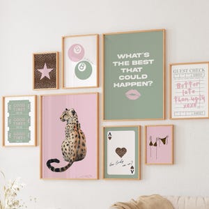 May include: A gallery wall of framed art prints with diverse designs. Features a leopard print star, a leopard print cat, a green print with the text "GOOD TIMES", a green print with the text "WHAT'S THE BEST THAT COULD HAPPEN?", and a pink print with the text "Better late than ugly xoxo".