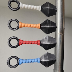 Four magnetic kunai stuck to a metal rod.