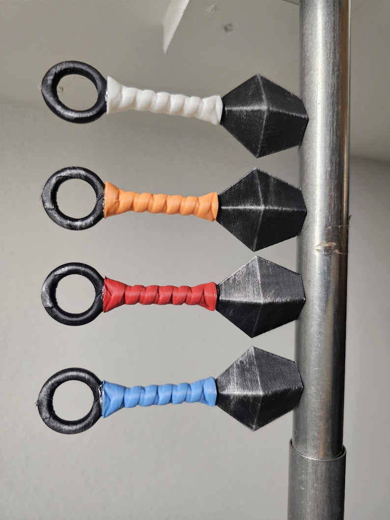 Four magnetic kunai stuck to a metal rod.