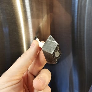 Magnetic kunai layed over to display the magnet underneath