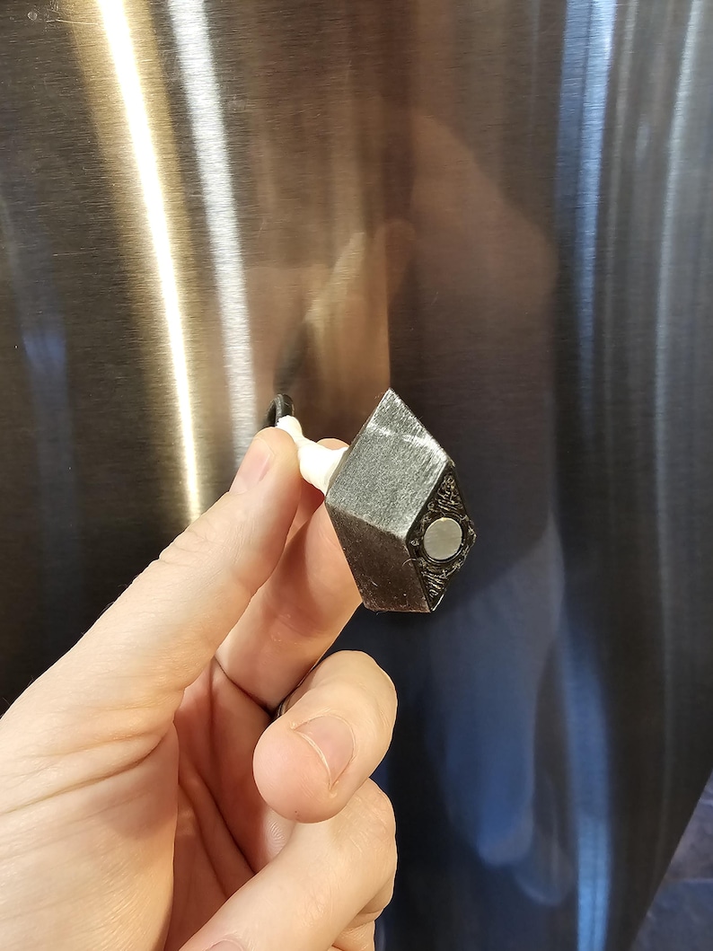 Magnetic kunai layed over to display the magnet underneath