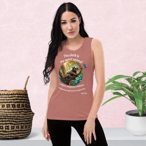 May include: A rust-colored tank top with a graphic of a sloth in a tree. The text on the shirt reads "The sloth is my spirit animal. Patience, simplicity, kindness. Comparable energy level on any given day. ME/CFS"