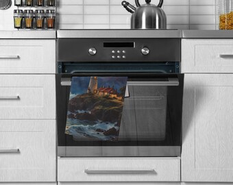 May include: A kitchen towel featuring a lighthouse scene, hanging on an oven door. The artwork depicts a white lighthouse with a red-roofed building on a rocky coast, illuminated at night. The towel is rectangular and made of fabric.