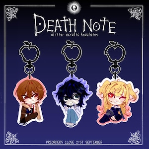 May include: Three glitter acrylic keychains featuring Death Note characters with black apple-shaped clasps. The text reads Death Note glitter acrylic keychains and Preorders close 21st September. The characters are chibi-style illustrations.