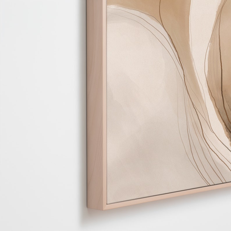 May include: Abstract art print in a light wood frame. The artwork features a watercolor design with soft beige and brown tones, and delicate linear details. The frame has a natural wood finish.