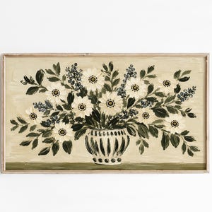 Puede incluir: Una impresión de arte mural rectangular horizontal que presenta una pintura al óleo de un ramo de flores blancas con hojas verde oscuro y pequeños acentos azules en un jarrón a rayas sobre un fondo beige claro con una base verde oscuro.