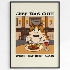 Puede incluir: Un estampado enmarcado que presenta un gato de dibujos animados cenando en un restaurante. El gato, con pajarita, está comiendo un bistec. El texto dice "CHEF WAS CUTE" y "WOULD EAT HERE AGAIN". El restaurante incluye mesas, sillas y apliques de pared.