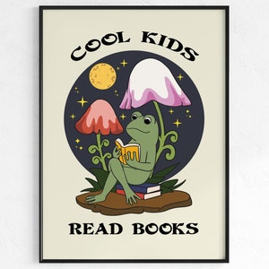 Puede incluir: Una rana verde sentada debajo de un hongo rosa y blanco leyendo un libro. El fondo es azul oscuro con estrellas y una luna amarilla. El texto dice "Cool Kids Read Books".