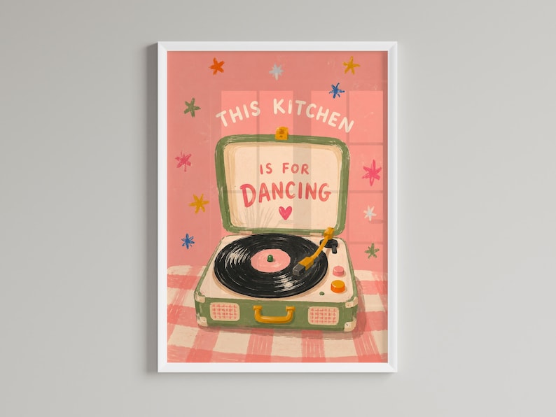 May include: A framed art print featuring a vintage-style record player with the text "THIS KITCHEN IS FOR DANCING." The artwork has a pink and green color scheme with star and heart accents, set against a checkered background.